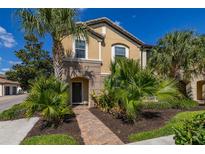 Charming home featuring lush tropical landscaping, a brick walkway, and a welcoming facade at 8960 Adriatico Ln, Kissimmee, FL 34747