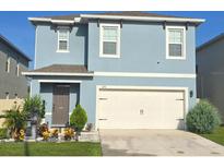 Charming two-story home featuring a well-manicured front yard and a two car garage at 1292 Cascades Ave, Davenport, FL 33837