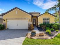 Charming home featuring a well-manicured lawn, a two-car garage, and tasteful landscaping at 208 Almeria Way, Davenport, FL 33837