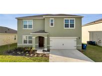 Two-story home with a spacious two car garage, neutral colored stucco and inviting front yard at 417 Noble Ave, Davenport, FL 33837