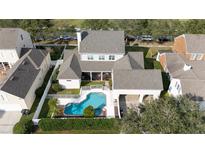 An aerial view of a spacious property featuring a sparkling blue pool and attached garage at 614 Golfpark Dr, Kissimmee, FL 34747