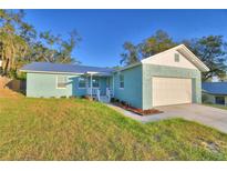 Charming home features a well-maintained lawn, a one car garage, and a light blue exterior at 713 Greenleaf Ln, Lake Wales, FL 33853