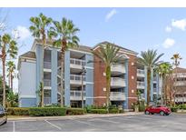 Beautiful condo exterior with tropical landscaping, balconies, and parking at 7652 Whisper Way # 401, Reunion, FL 34747