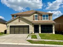 Two-story home featuring neutral colors, a two-car garage, and well-maintained landscaping at 144 Bella Dr, Davenport, FL 33837