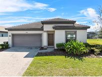 Charming one-story home featuring a two car garage, tiled roof, and well-manicured lawn at 194 Aidans Lndg, Haines City, FL 33844