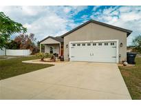 Charming single-story home featuring a well-manicured lawn, a two-car garage and inviting front porch at 2038 Lily Pl, Kissimmee, FL 34759