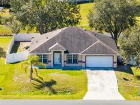 Charming single-story home featuring a well-manicured lawn, attached garage, and welcoming front entrance at 2938 Foraker Way, Kissimmee, FL 34758