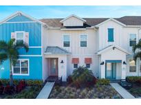 Inviting home exterior featuring colorful siding, a well-maintained lawn, and lush, tropical landscaping at 2980 Caribbean Soul Dr, Kissimmee, FL 34747