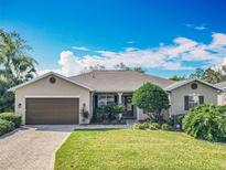 Inviting single-story home boasts lush landscaping, complemented by a brick-paved driveway and a two-car garage at 328 Hamrick Dr, Kissimmee, FL 34759