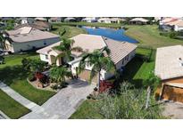 Aerial view of a landscaped property with a tile roof and a view of a pond in the backyard at 4018 Navigator Way, Kissimmee, FL 34746