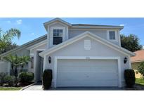 Two-story home featuring a two-car garage, neutral paint, and manicured landscaping at 525 Garberia Dr, Davenport, FL 33837