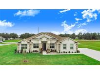 Charming single-story home featuring stone accents and a well-manicured lawn at 944 Lochland Loop, Bartow, FL 33830