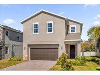 Charming two-story home boasts neutral stucco, a two-car garage, and professionally landscaped front yard at 1252 Ash Tree Cv, Casselberry, FL 32707