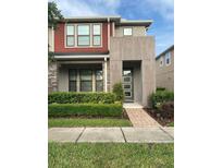 Charming two-story home with a modern design, stone accents, and manicured landscaping at 2546 Amati Dr, Kissimmee, FL 34741