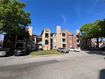 Exterior view of building with a parking lot, green grass, with beautiful blue skies at 4200 Thornbriar Ln # 208, Orlando, FL 32822