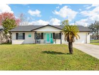 Charming single-story home featuring a welcoming porch, nicely manicured lawn, and freshly painted exterior at 725 Montana Ave, St Cloud, FL 34769