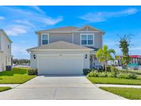 Charming two-story home with attached two-car garage, landscaped yard, and freshly painted exterior at 1562 Delightful Dr, Davenport, FL 33896