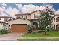 Charming two-story home featuring a tile roof, arched entry, and a well-manicured lawn at 10467 Henbury St, Orlando, FL 32832