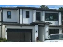 Two-story modern home with a spacious garage and white stucco exterior at 1319 Butterfly, Davenport, FL 33837