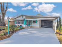 Charming home exterior with carport, vibrant landscaping, and a welcoming entrance at 145 Kensington Park Dr, Davenport, FL 33897