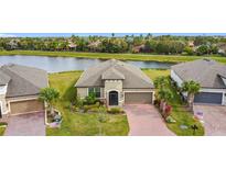 Beautiful single-Gathering home showcasing brick driveway, well-manicured lawn, and picturesque water view at 1930 Molise Dr, Poinciana, FL 34759