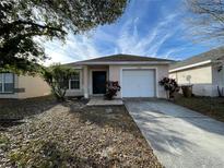 Charming single Gathering home featuring a well-maintained yard and a one car garage at 2408 Cedarfield Ln, Kissimmee, FL 34744