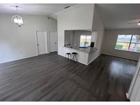 Bright and airy living room with a partial view of the kitchen and modern bar stool seating at 3216 Fieldcrest Ter, Deltona, FL 32725