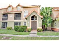 Charming two-story condo with a well-manicured lawn, beautiful landscaping, and a tile roof at 425 Fountainhead Cir # 107, Kissimmee, FL 34741