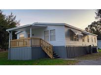 Charming single-story home featuring a covered front porch with wooden railing and a two-tone exterior at 4805 1St Nw St, Lakeland, FL 33810