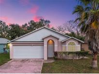 Charming single-story home featuring a well-manicured lawn and a two-car garage at 4941 Luna Negra Dr, Orlando, FL 32811