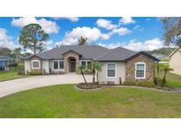 Charming stone accent home with well-manicured lawn and beautiful landscaping at 6301 Oak Shore Dr, St Cloud, FL 34771