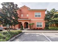 Charming two-story home with a peach exterior, well-manicured landscaping, and a parking spot at 8984 Cuban Palm Rd, Kissimmee, FL 34747