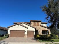 Beautiful two-story home with a brick driveway, two-car garage, and stone accents at 10902 Citron Oaks Dr, Orlando, FL 32836