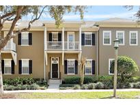 Charming townhome with black shutters, small balconies and landscaped yard at 1343 Flagstone Ave, Celebration, FL 34747