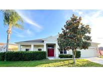 Charming single-story home with a red front door and manicured landscaping in a sunny setting at 1966 Derby Glen Dr, Orlando, FL 32837
