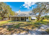 Charming cottage-style home with a screened porch and well-maintained lawn at 2921 Seminole Rd, St Cloud, FL 34772