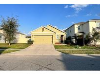 Charming single-Gathering home with a well-manicured lawn and a two-car garage with a neutral color scheme at 3211 Surfbird St, Kissimmee, FL 34744