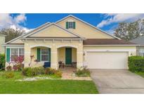 Charming single-story home with a well-manicured lawn, covered porch, and attached two-car garage at 3452 Goldeneye Ln, St Cloud, FL 34772