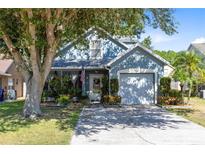 Charming home with mature shade trees, a covered front porch, and a two-car garage at 3741 Crossing Creek Blvd, St Cloud, FL 34772