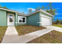 Lovely, bright home featuring a one car garage, and manicured lawn under a beautiful blue sky at 6430 Sw 144Th Street Rd, Ocala, FL 34473