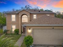 Charming two-story home featuring an attached two-car garage and lush landscaping in a well-maintained community at 10409 Laxton St, Orlando, FL 32824