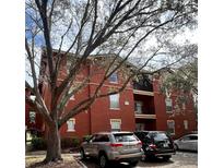 Exterior view of the red brick condo building with black balconies and visible parking area at 107 Vista Verdi Cir # 129, Lake Mary, FL 32746