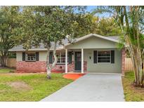 Charming single-story home features a well-manicured lawn, mature trees, and inviting front porch at 1506 Maryland Ave, St Cloud, FL 34769