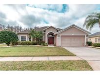 Charming single-story home with a well-manicured lawn, beautiful landscaping, and a two-car garage at 2512 Volta Cir, Kissimmee, FL 34746