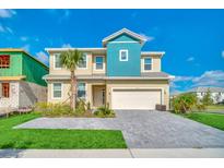 Inviting two-story home boasting blue accents, manicured landscaping, and a spacious two-car garage at 2536 Shanti Dr, Kissimmee, FL 34746