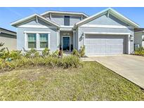 Charming home featuring a well-manicured front yard, a two-car garage and a stylish blue front door at 281 Piave St, Haines City, FL 33844