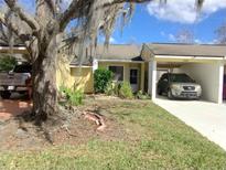 Charming single-story home featuring a carport, well-maintained lawn, and mature landscaping at 492 Prestwick Pl # 2, Kissimmee, FL 34759