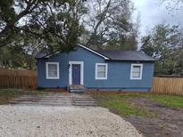 Charming blue home with a well-maintained exterior, a gravel driveway, and a neat front yard at 7709 Bell Blvd, Orlando, FL 32810