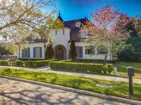 Charming two-story home features a turret, arched entry, manicured lawn, and mature landscaping at 885 Spring Park Loop, Celebration, FL 34747