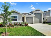 Beautiful single-Gathering home featuring a three-car garage and well-manicured lawn at 1115 Olivine Ave, Dundee, FL 33838